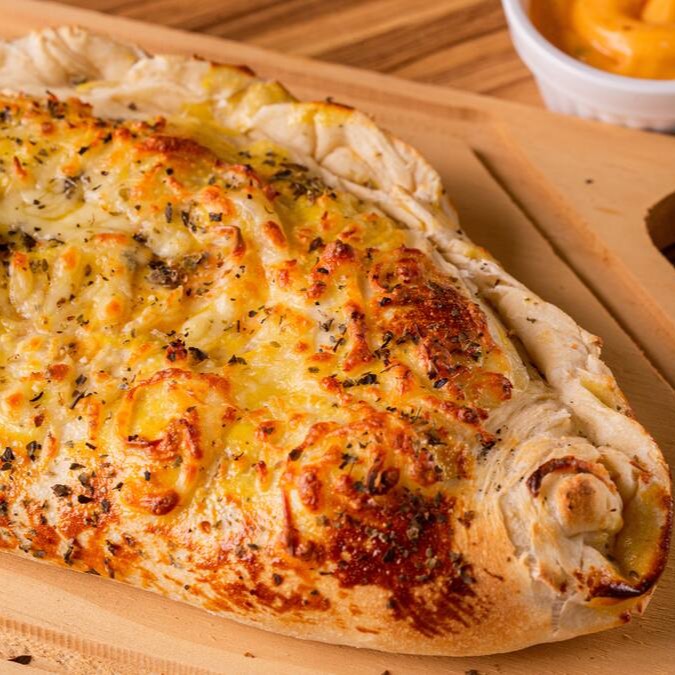 Molho, muçarela, calabresa em fatias, requeijão cremoso, ovos cozidos e orégano