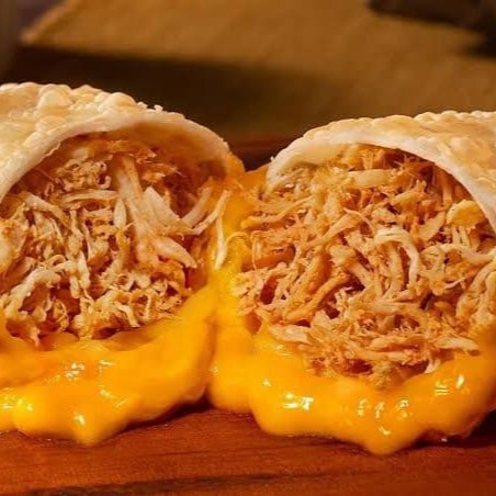 Delicioso pastel de frango desfiado recheado com cheddar derretido, crocante por fora e irresistível por dentro. Aproveite!