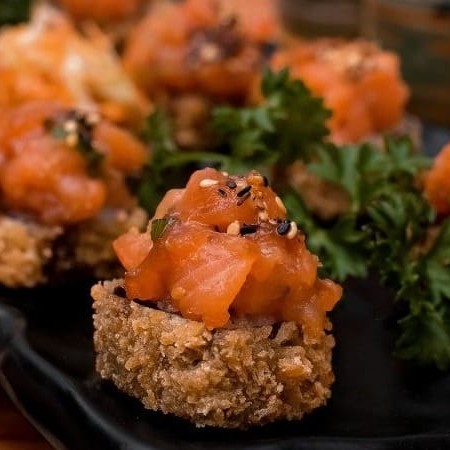 Porção com 10 unidades. Hot Roll na casquinha de Harumaki, com tartar de salmão, arroz, geleia de pimenta, cream cheese, cebolinha e crispy de alho poró.