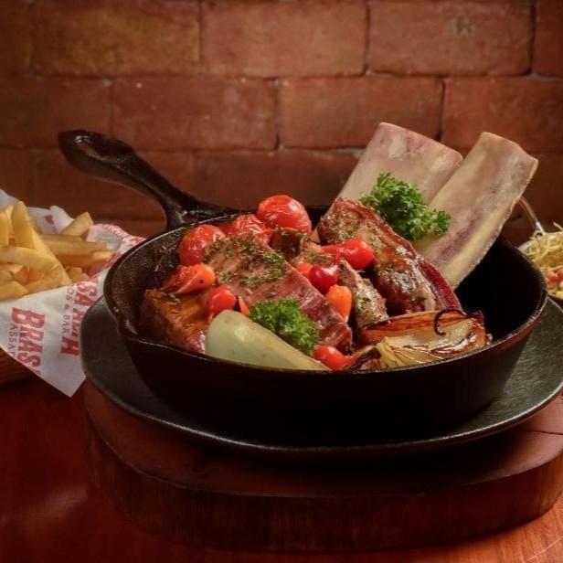 O diferencial da costela bovina preparada na casa é o leve defumado e a perfeita cocção após 8hs no nosso Pit Smoker. O preparo ocorre em duas etapas: 1 Defumando a costela durante 3 horas. 2 Cozinhando por 5 horas. Um total de 8 horas de preparo.  Servida com 2 acompanhamentos e em nova montagem.