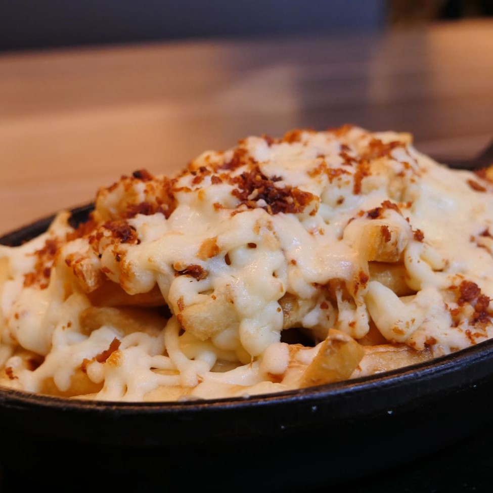 Deliciosa porção de fritas com Catupiry e bacon finalizada com uma camada de queijo gratinado por cima!