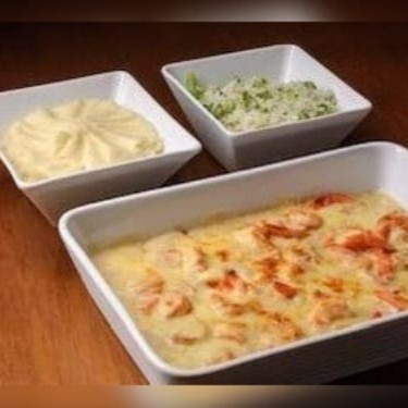 Camarões suculentos envoltos em um cremoso Catupiry, servidos com arroz de brócolis fresquinho e purê suave. Uma combinação irresistível de sabores e texturas que trazem leveza e sofisticação a cada garfada.