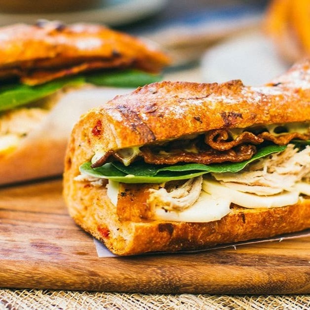 Pão baguete, frango grelhado, queijo, alface, tomate e molho da casa (mostarda com mel)