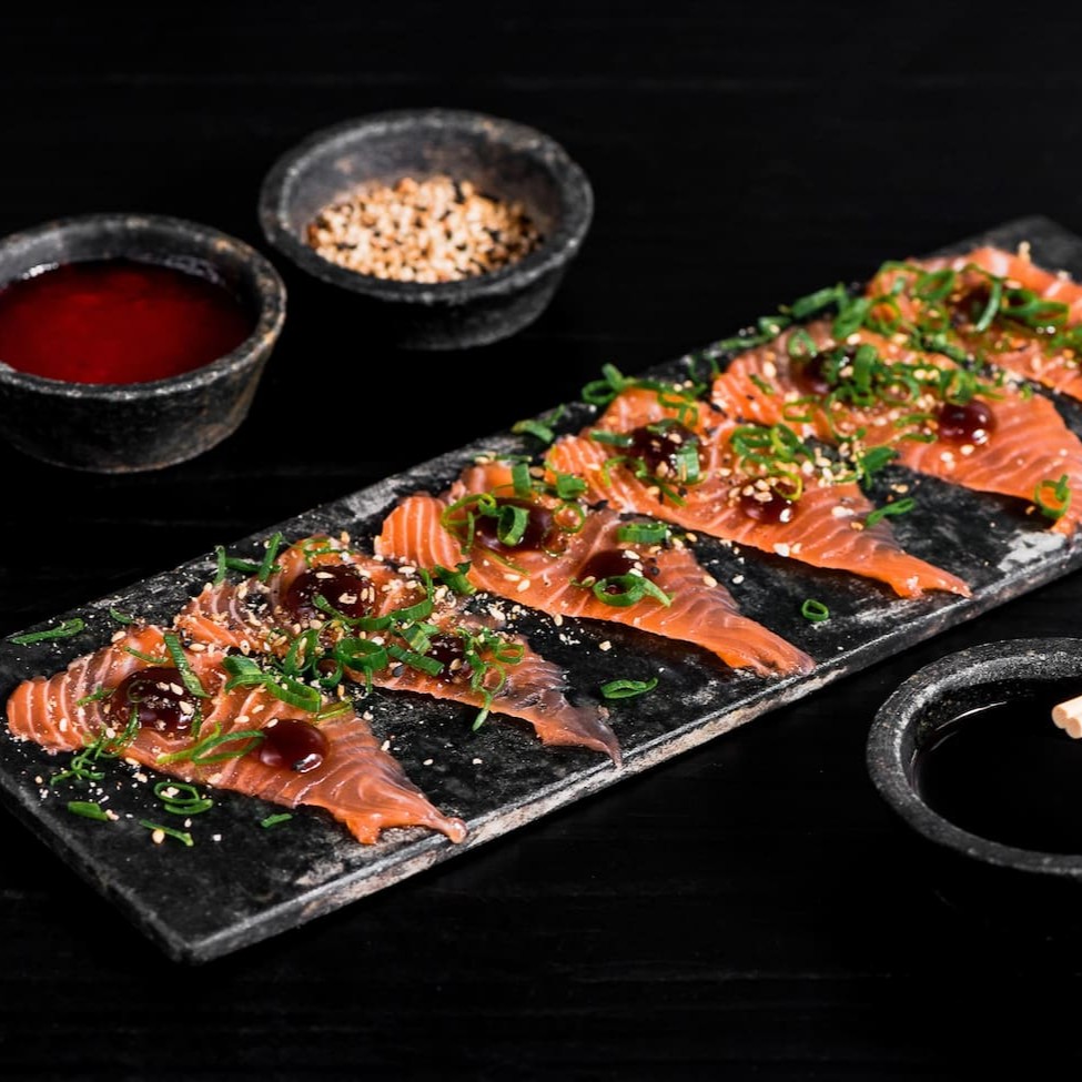 Lâminas de salmão finalizado com teriaky, farofa de gergelim e cebolinha.