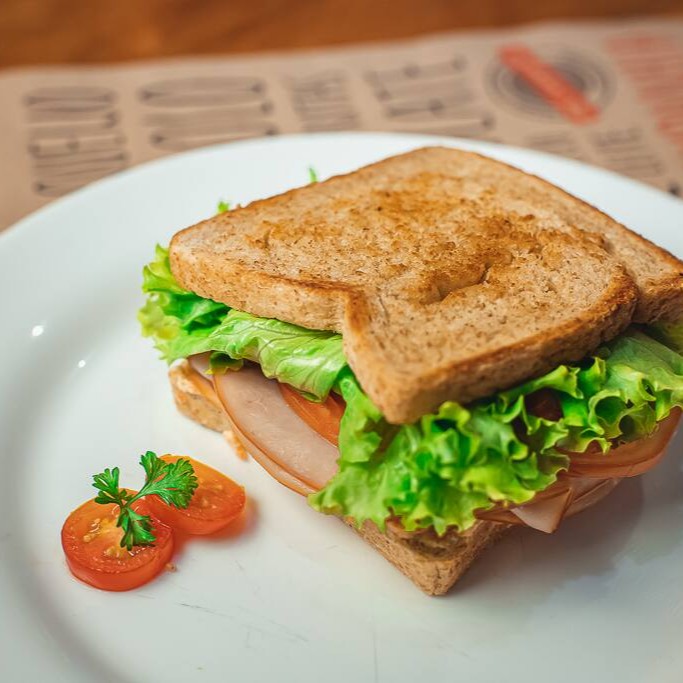 Pão de forma integral, pasta natural, peito de peru, alface e tomate