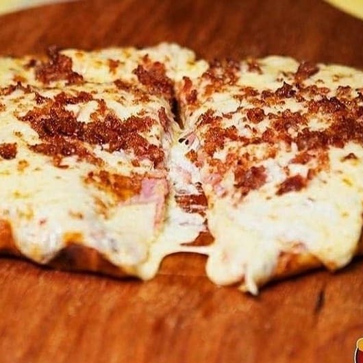 Maravilhoso calzone recheado com 3 queijos tipo, mussarela, parmesão e requeijão cremoso, finalizado com molho secreto Poderosa, queijos provolone e parmesão, e bacon.