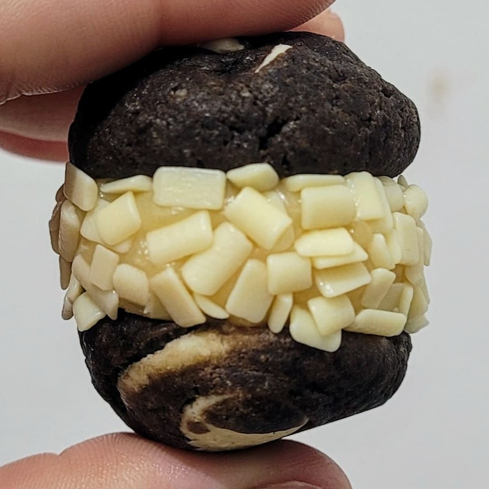 Nosso cookie triplo chocolate, feito com cacau e mix de gotas de chocolate ao leite e branco, recheio de brigadeiro branco cremoso