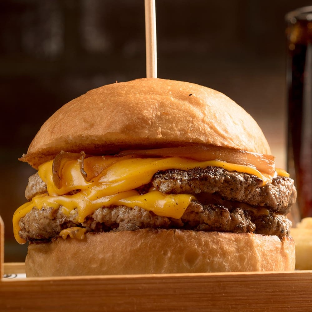 Pão rústico, duas carnes de 110g, queijo cheddar e cebola grelhada + batata especial com cheddar e bacon.