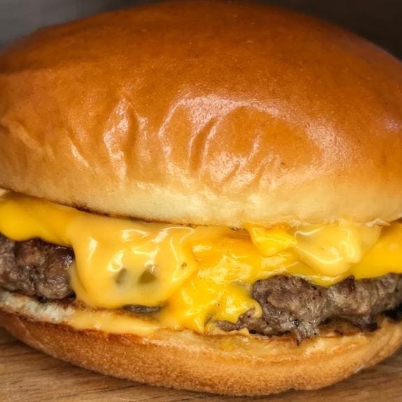 Pão Brioche, 1 carne smash 100g, fatia de queijo Cheddar Polenghi e Molho Fire.