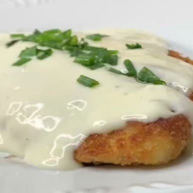 Filé de Tilápia empanado ao molho branco por cima, finalizado com  uma cobertura de queijo mussarela derretido.  Marmita composta por arroz branco, feijão preto, farofa da casa, mais um acompanhamento a escolher.