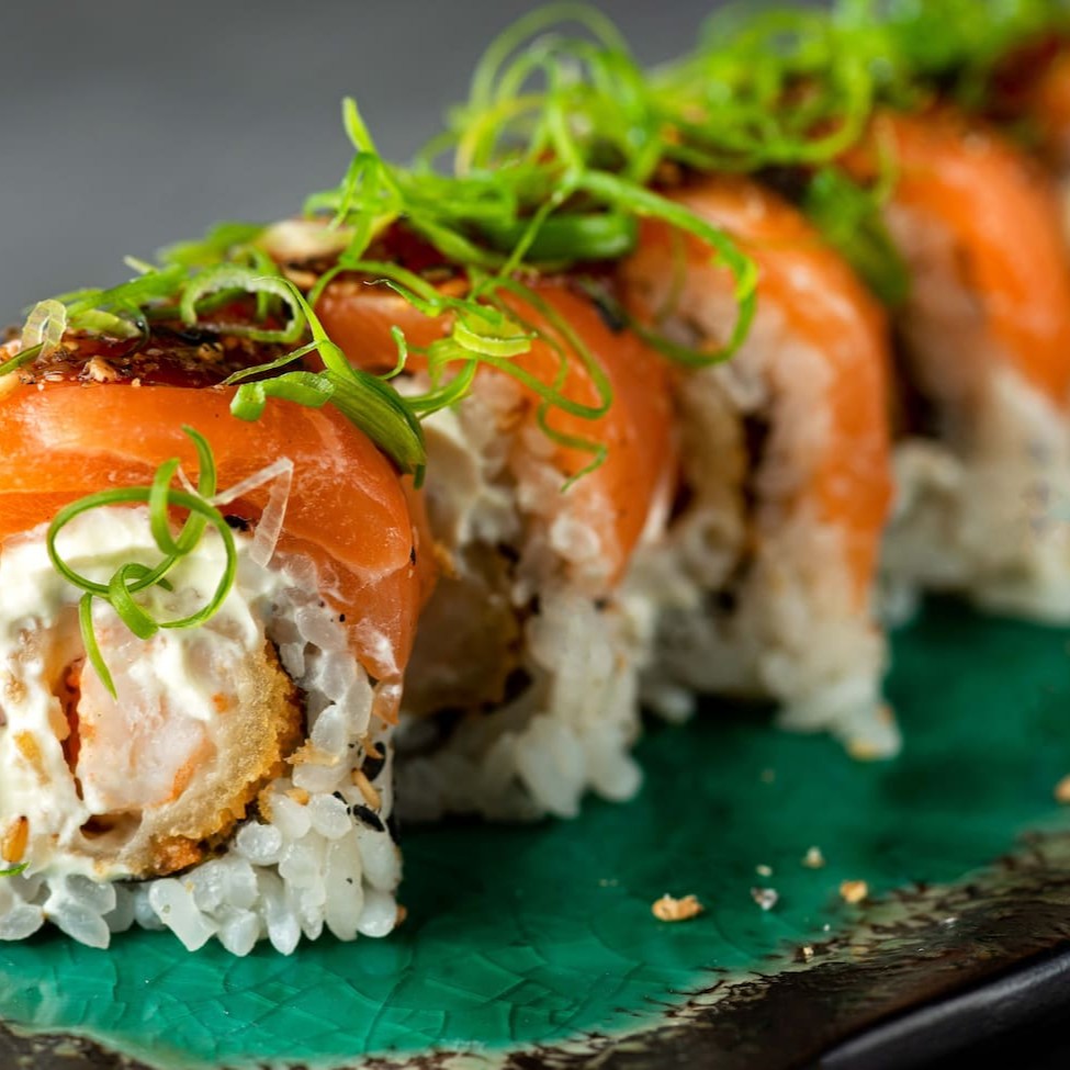 Uramaki de camarão empanado com cream cheese envolto por lâmins de salmão maçaricado com toque de teryaki e cebolinhas pr dar frescor. Vem 10 unidades
