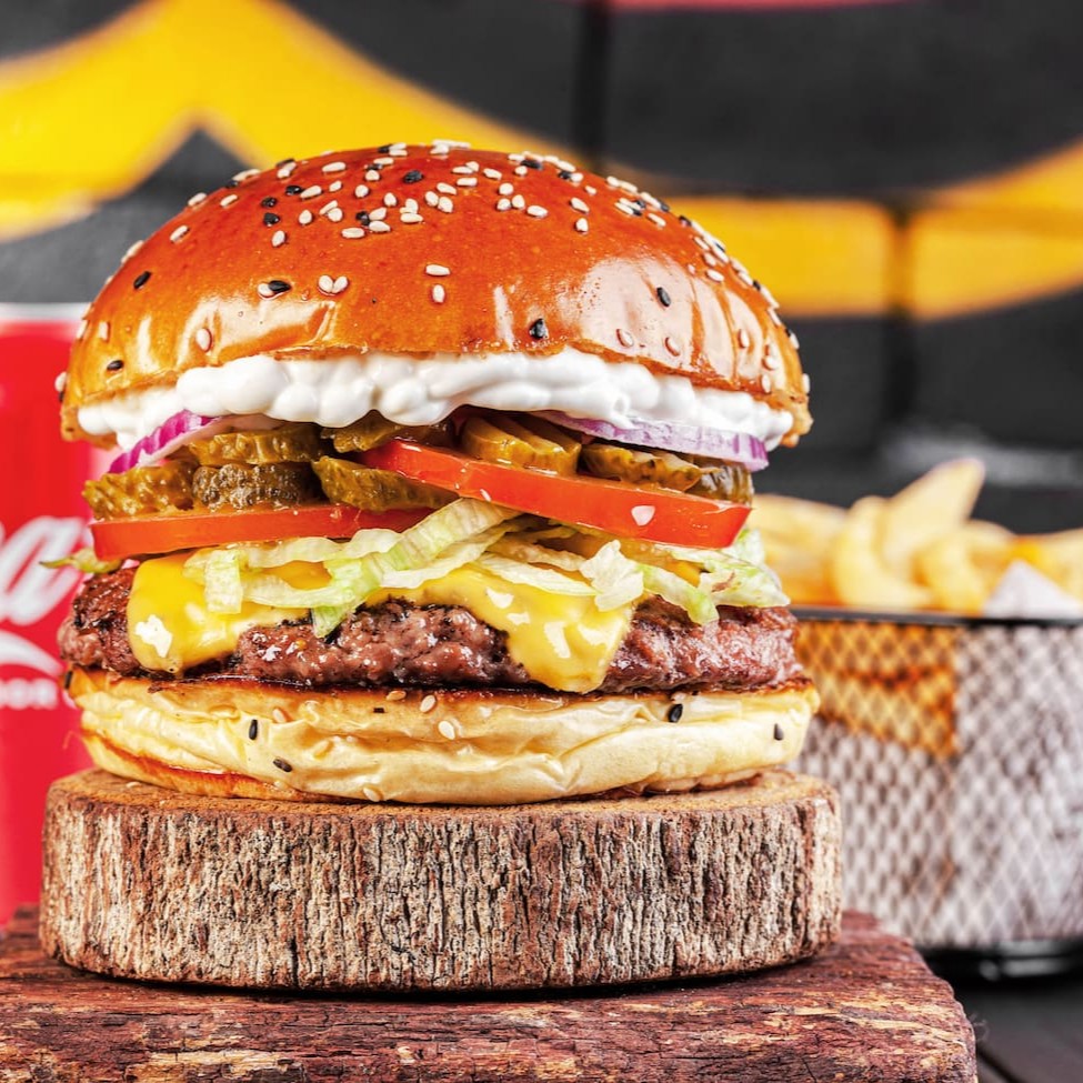 Pão brioche fresquinho e levemente crocante, salpicado de gergelim. No coração do prato, um generoso blend de 160g, cuidadosamente grelhado para ressaltar sua suculência. Para completar essa combinação perfeita, uma fatia de queijo mussarela derretida, picles crocantes que acrescentam um toque ácido e uma fresca salada de alface, tomate e cebola roxa, proporcionando um contraste de sabores. A maionese de alho caseira finaliza o prato, adicionando um toque cremoso e um sabor rico e robusto. + Acompanhamento + Bebida.