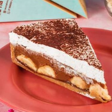 A tradicional e sofisticada torta à base de biscoito com uma camada do nosso doce de leite artesanal, bananas frescas e selecionadas, uma cobertura caprichada de chantily e uma generosa quantidade de cacau polvilhado.