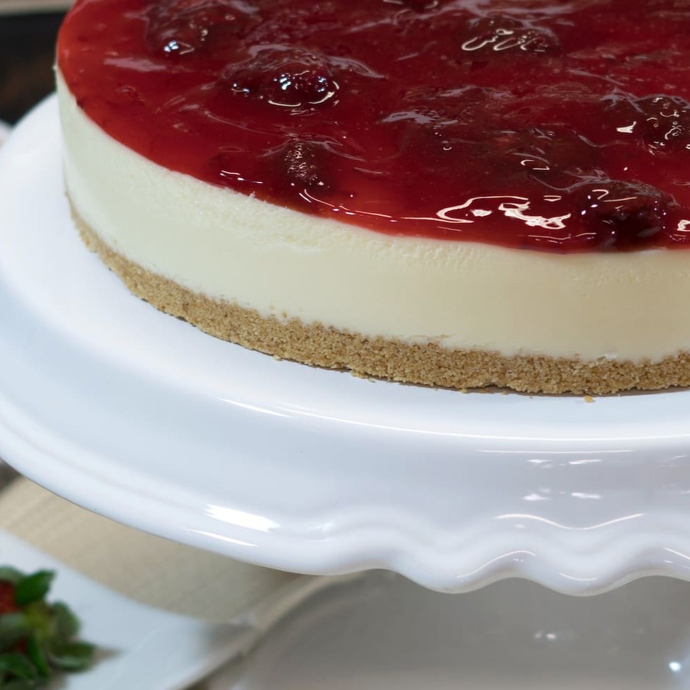 Delicioso creme de queijo sobre fina camada de biscoito e coberto de geléia de morango.   Diâmetro de 24 cm servindo aprox. 20 fatias