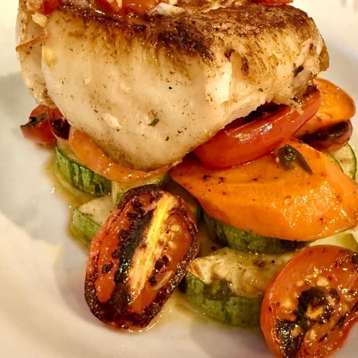 Robalo, sobre abobrinha, cenoura e tomatinhos, conflitados em azeite e gremolata tomate seco.