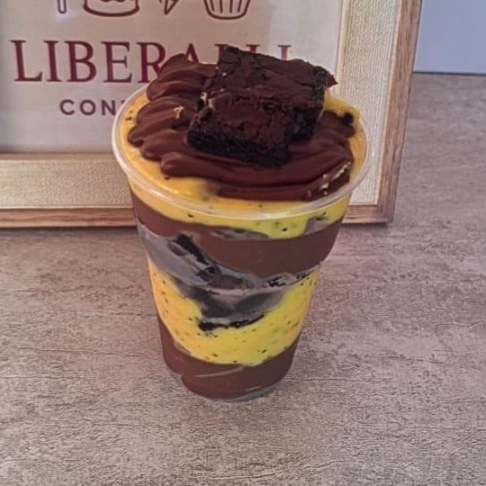 Copo especial com mousse de maracujá cremoso, chocolate, brownie e pedacinhos de chocolate.