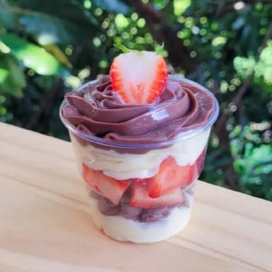 Creme Moça super cremoso, brigadeiro de chocolate cremoso, morango picados e gotas de chocolate. (Copo 150ml)