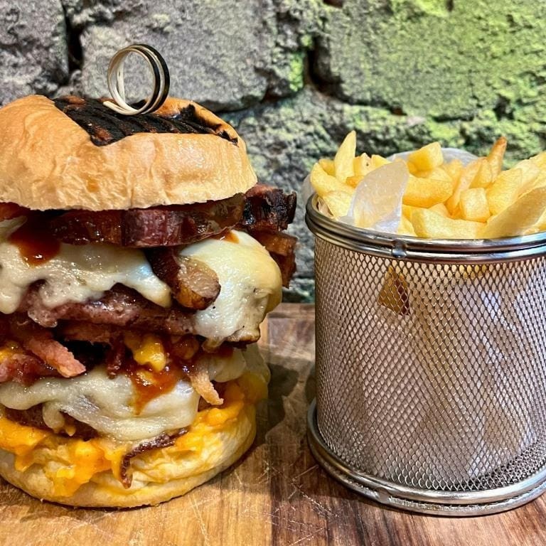 Dois hambúrgueres de 220 gramas de carne suína, queijo, muito bacon, barbecue e maionese da casa.