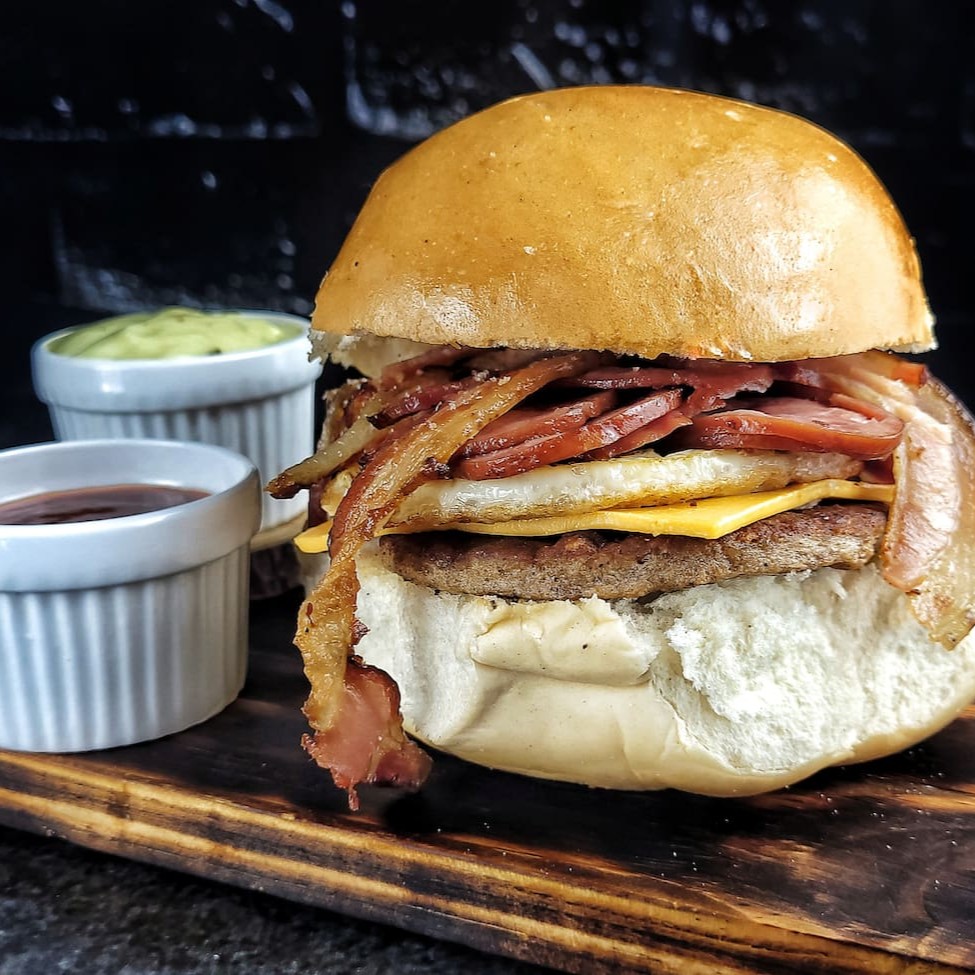 Deleite-se com nosso 'X-Tudo', a estrela da categoria ' Sanduíches americanos'. Este inigualável sanduíche é composto por um pão bola irresistivelmente macio, uma generosa camada de carne suculenta, queijo cheddar derretido, , um ovo perfeitamente cozido, crocantes tiras de bacon e saborosa calabresa. Acrescentamos ainda nosso exclusivo e secreto molho da casa e ketchup