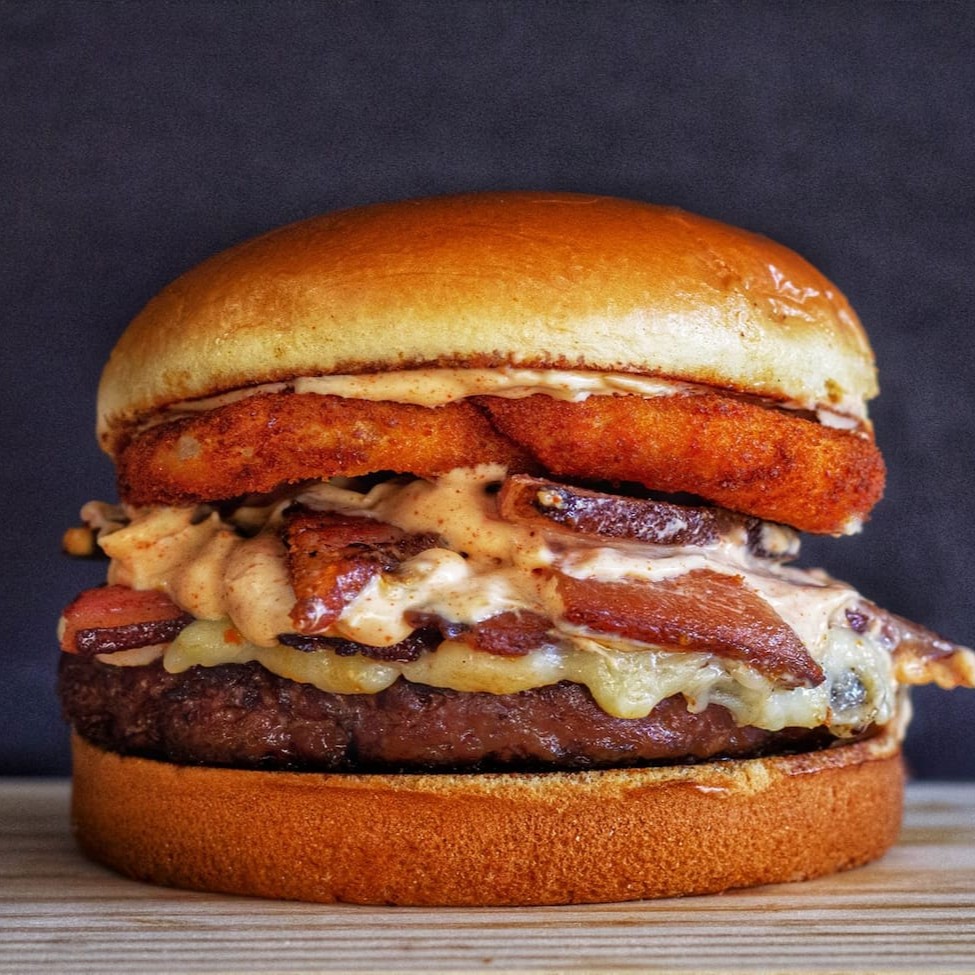 Pão, Carne 100g, mussarela com requeijão,2 cebola empanada, bacon, molho Gourmet (pápricas e alho poró)