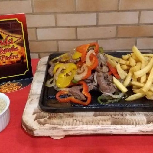 Apresentamos a você o nosso '537 - Filé Aperitivo com Fritas', uma novidade irresistível. Finas e suculentas fatias de filé, cuidadosamente grelhadas na chapa, são combinadas com uma explosão de sabores de cebola e tricolor de pimentões. Tudo isso é realçado por nosso tempero secreto, que agrega um toque especial ao prato. Acompanha uma generosa porção de batatas fritas, crocantes e douradas, além da nossa deliciosa farofa. Uma combinação perfeita para um aperitivo de dar água na boca.