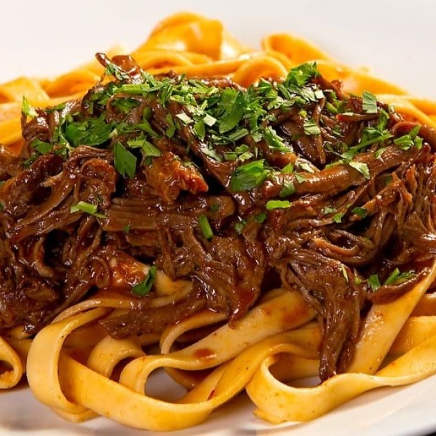 O Chef Barros tem o prazer de apresentar o delicioso 'Fettuccini ao Molho Sugo com Isca de Carne'. Este prato elegante e saboroso é feito com fettuccini de alta qualidade, banhado em um molho sugo caseiro rico e intenso. As iscas de carne, perfeitamente temperadas e macias, complementam a massa, criando uma sinfonia de sabores que vai encantar o seu paladar. Uma autêntica experiência culinária italiana que não deixa nada a desejar. Imperdível!