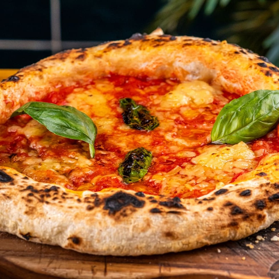 Mussarela vegana, parmesão vegano, molho de tomate, azeite de alho e manjericão
