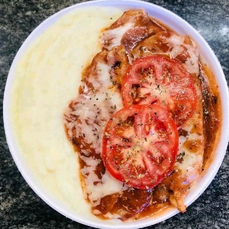Suculento filé de frango grelhado, coberto por uma camada de queijo, banhado com molho de tomate caseiro, duas rodelas de tomate e uma pitada de orégano na finalização. Acompanha arroz, feijão e farofa. Escolha entre: purê, salada, macarronese ou fritas.