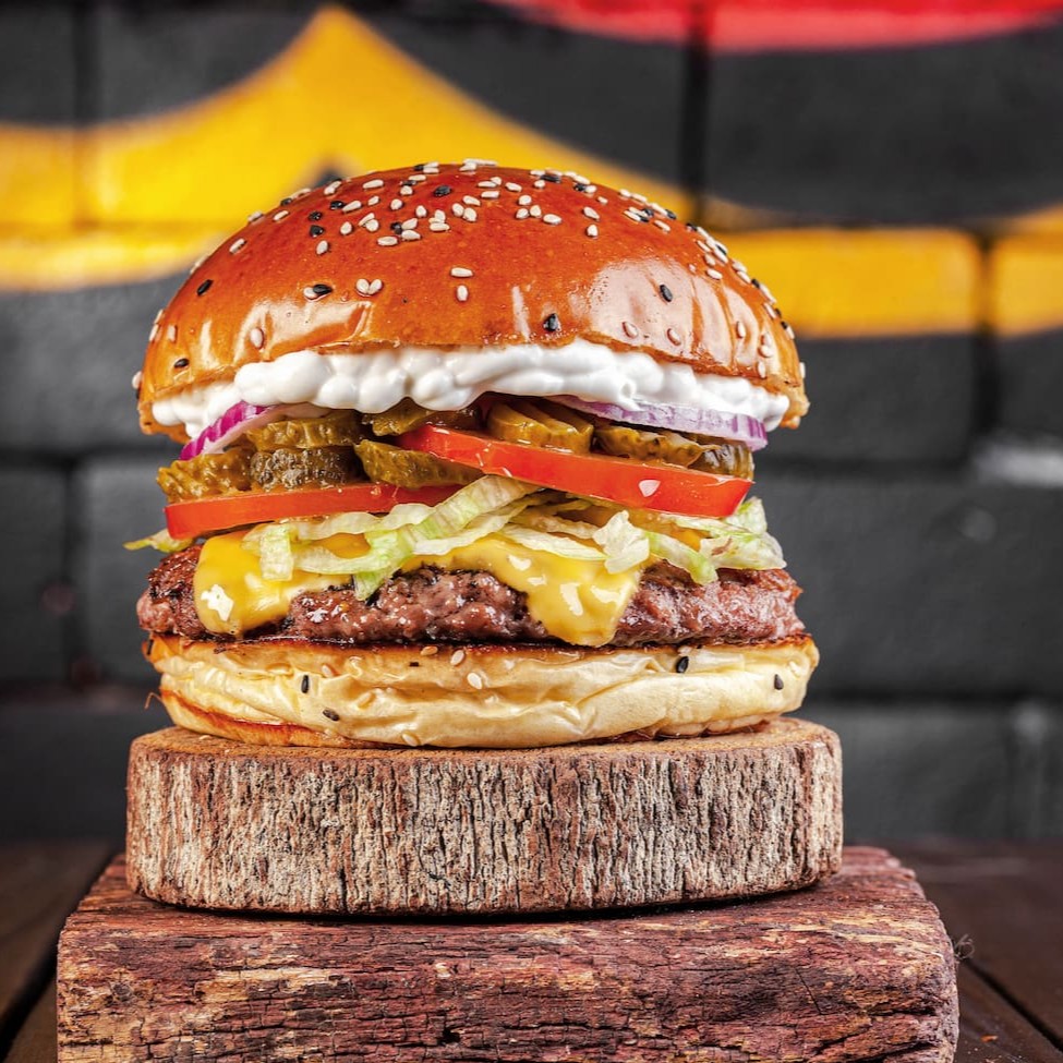 Pão brioche levemente crocante com gergelim, burger suculento de 160g, queijo derretido, picles crocante, saladinha fresca (alface, tomate e cebola roxa) e nossa maionese de alho artesanal. Simples, saboroso e viciante.