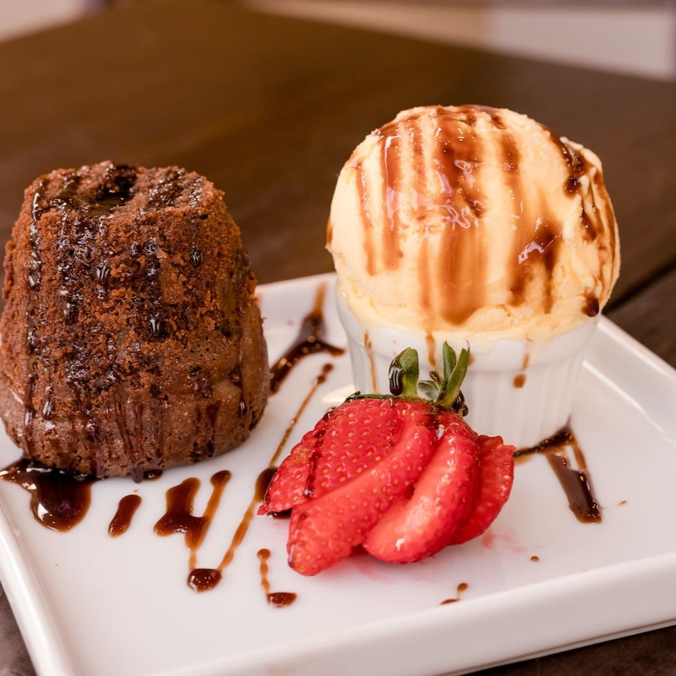 Nosso delicioso Petit Gateau é servido ao lado de um sorvete cremoso, proporcionando um contraste de temperaturas que aguçará seus sentidos. Para personalizar ainda mais a sua experiência, oferecemos uma seleção de coberturas à sua escolha. Tudo é cuidadosamente embalado e enviado separadamente em uma embalagem térmica para garantir que chegue em perfeitas condições. Aprecie a imagem, mas saiba que o sabor é ainda mais delicioso. Afinal, a foto é meramente ilustrativa.