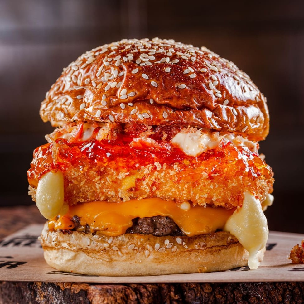 Blend 150g, queijo cheddar ou prato, muçarela empanada, geleia de pimenta, maionese de bacon, farofa de bacon, no pão de brioche prime.