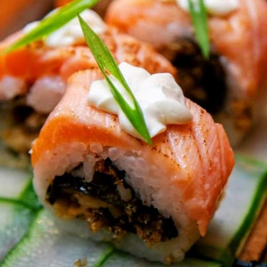 """Porção com 4 unidades de sushi skin, preparados com arroz temperado e cobertos com pele de salmão grelhada até ficar crocante, finalizados com gergelim tostado e molho teriyaki que adicionam um toque adocicado e aroma irresistível. Uma combinação perfeita de texturas e sabores que conquistam o paladar a cada mordida."""