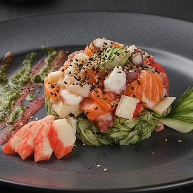 Pepino japonês fatiado marinado no molho agridoce com gergelim, kani e salmão fresco.