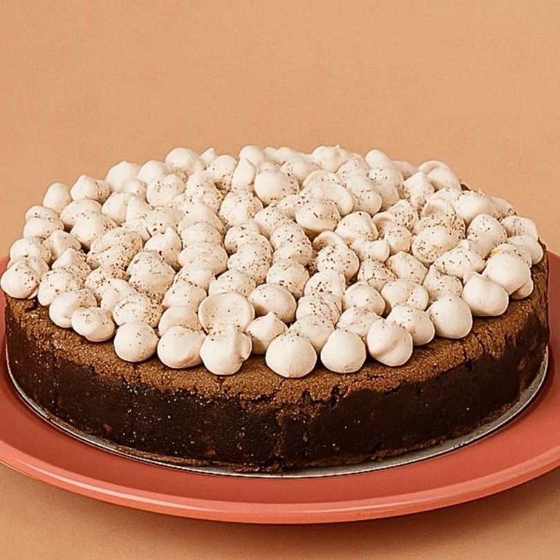 Esta doçura é primorosamente elaborada com ganache crocante, feito com chocolates de primeira linha e castanhas selecionadas. Sua textura é acentuada pela mousse de chocolate gourmet, envolta em uma sedutora cobertura de nosso autêntico doce de leite artesanal. A finalização se dá com nossos irresistíveis suspiros que se desmancham na boca, e uma suave chuva de cacau polvilhado. Sabores e texturas para tornar qualquer ocasião inesquecível.