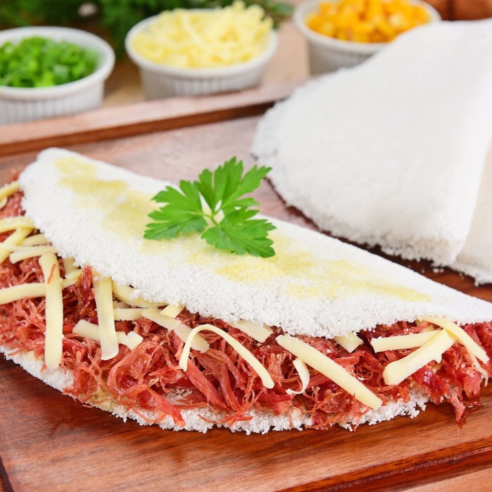 Delicie-se com a tradicional carne seca, acompanhada de queijo coalho derretido e cebola, criando uma combinação irresistível de sabores.