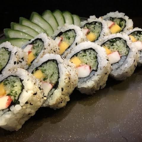 Uramaki Califórnia enrolado de arroz e gergelim por fora e recheado por dentro de pepino japonês, kani e manga