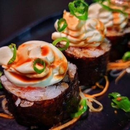 Makimono philadelfia, finalizado com cream cheese, molho teriaki, gergelim e cebolinha.

Delicioso makimono no estilo Philadelphia que une a suavidade do salmão com a cremosidade do cream cheese em um enrolado clássico e reconfortante. As peças são finalizadas com uma camada extra de cream cheese, molho teriyaki levemente adocicado, gergelim e cebolinha, elevando o sabor e acrescentando complexidade ao prato. Perfeito para quem procura uma experiência cremosa e cheia de sabor, equilibrando suavidade, dulçor e um leve toque de frescor.