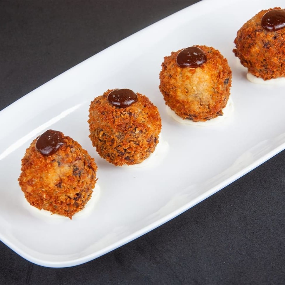 Saborosos bolinhos de costela bovina defumada, sem massa, preparados por 8 horas com dry rub exclusivo. Desfrute de 4 unidades perfeitamente temperadas e acompanhe com o molho especial da casa. Uma experiência irresistível!