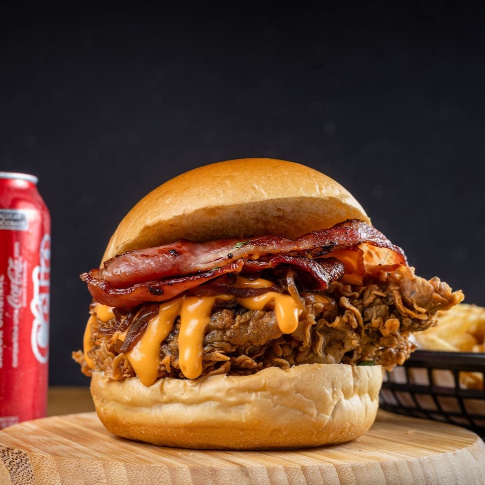 Filé de sobrecoxa crispy (ou 2 filezinhos de peito), coberto com molho cheddar cremoso, molho grill, bacon crocante e cebola caramelizada — tudo no pão brioche macio. Acompanha batata P crocante e 1 bebida gelada. Um hambúrguer intenso, marcante e simplesmente viciante! Uma combinação irresistível que une crocância e sabor na medida certa!