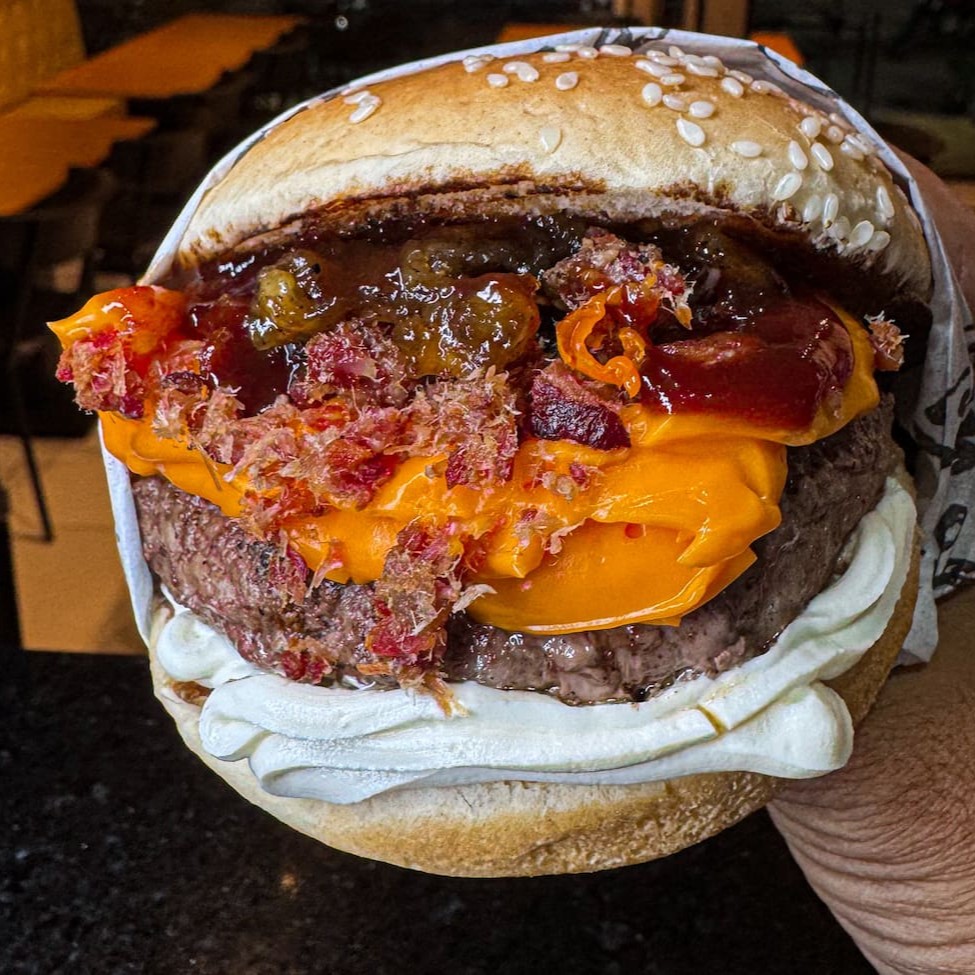 Pão tradicional com gergelim, cream cheese, blend suculento de 150g, cheddar cremoso, geleia de bacon (contém abacaxi) e barbecue
