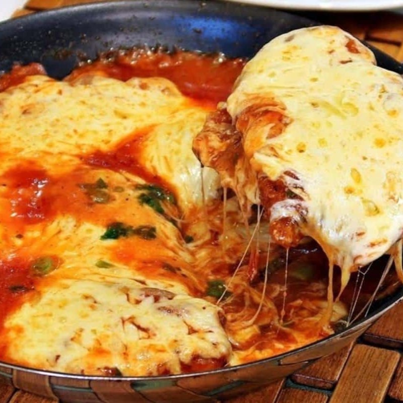 Filé de frango com uma generosa camada de queijo mussarela com molho de tomate por cima derretendo toda camada de queijo, deixando este prato ainda mais gostoso. Refeição composta por arroz branco, feijão preto, farofa da casa mais uma guarnição a escolher.