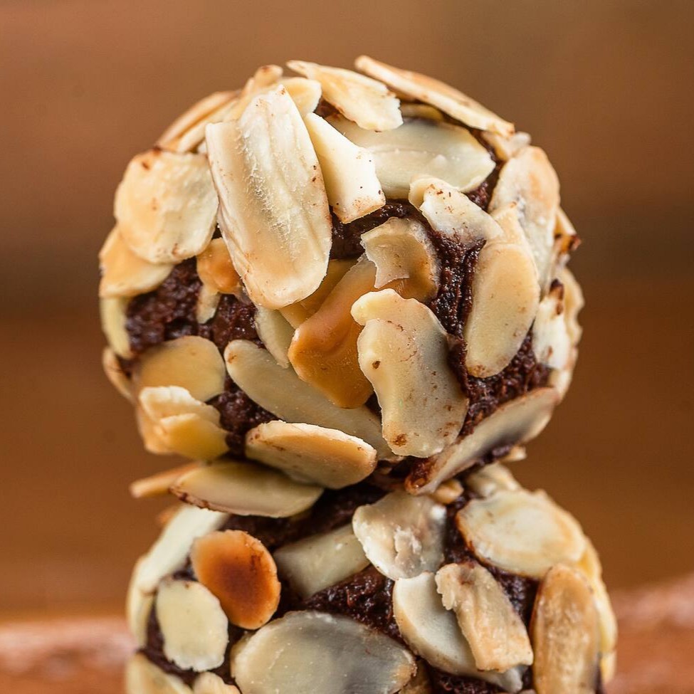 Tâmaras, farinha de amêndoas, cacau 100%, xylitol finalizadas com amêndoas