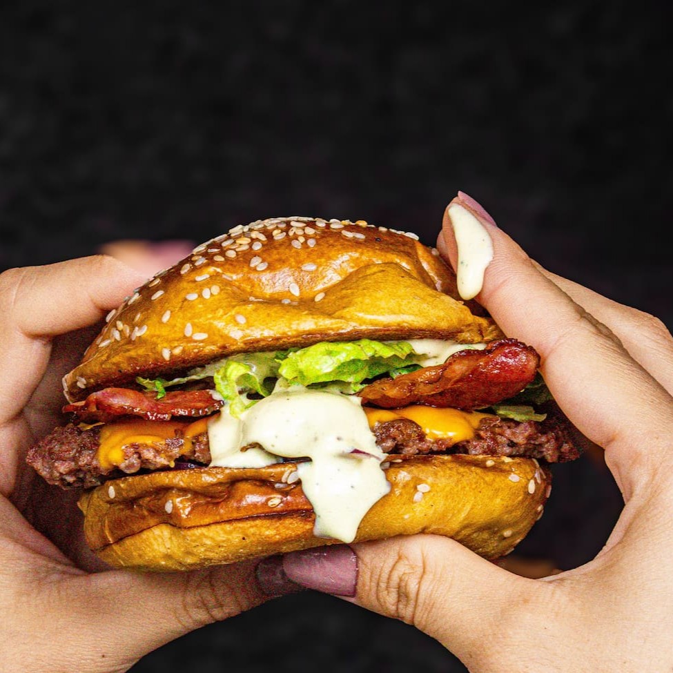 Pão de brioche ou Australiano, um smash de 80gr, cheddar ou Mussarela, Cebola roxa, alface, tiras de bacon e molho especial