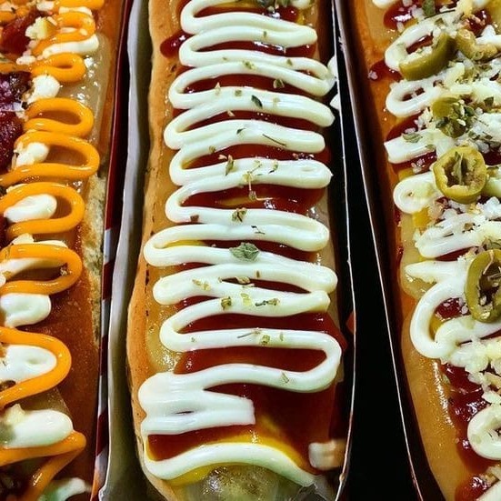 Super cachorro quente de 30cm, feito com pão artesanal fresquinho, salsicha ou linguiça Sadia, e muuuuuitos acompanhamentos e molhos inclusos, para montar do seu jeito!