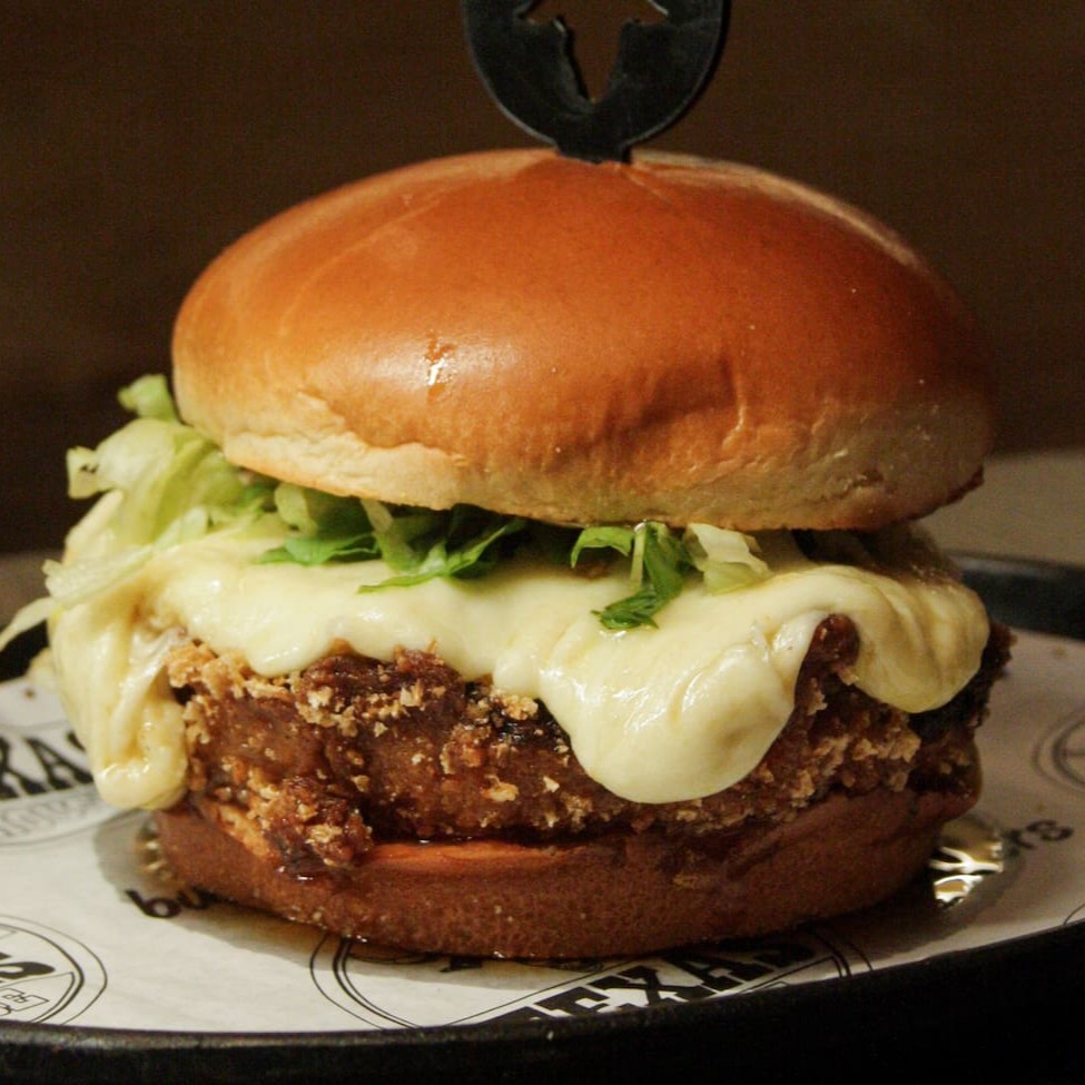 1 Blend de 160g de pernil suino defumado empanado, uma camada de queijo provolone gratinado, geleia de pimenta, alface. Acompanhados de fritas e bebida.