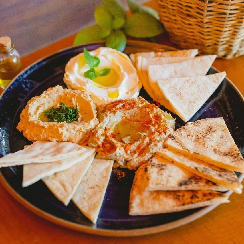 Descubra o encanto do 'Trio de Pastas'. Este prato inclui a suave e cremosa pasta de grão-de-bico conhecida como Homus, o Babaganoush, uma saborosa pasta de berinjela, e a Coalhada seca, um toque refrescante e ligeiramente ácido. Acompanha o irresistível pão árabe, perfeitamente assado, que complementa as pastas de maneira brilhante. Cada mordida é uma viagem ao autêntico sabor do Oriente Médio. Um verdadeiro deleite para os amantes de pastas!