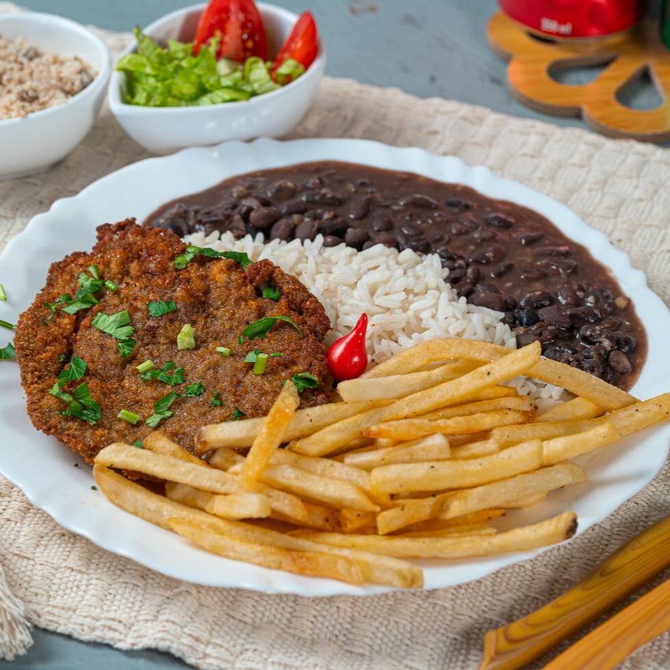 Bife suculento, empanado e frito até ficar dourado e crocante. Acompanha arroz soltinho, feijão caseiro bem temperado, batatas fritas crocantes, farofa saborosa e uma salada fresquinha para equilibrar os sabores. Uma refeição clássica e irresistível para matar a fome com muito sabor!