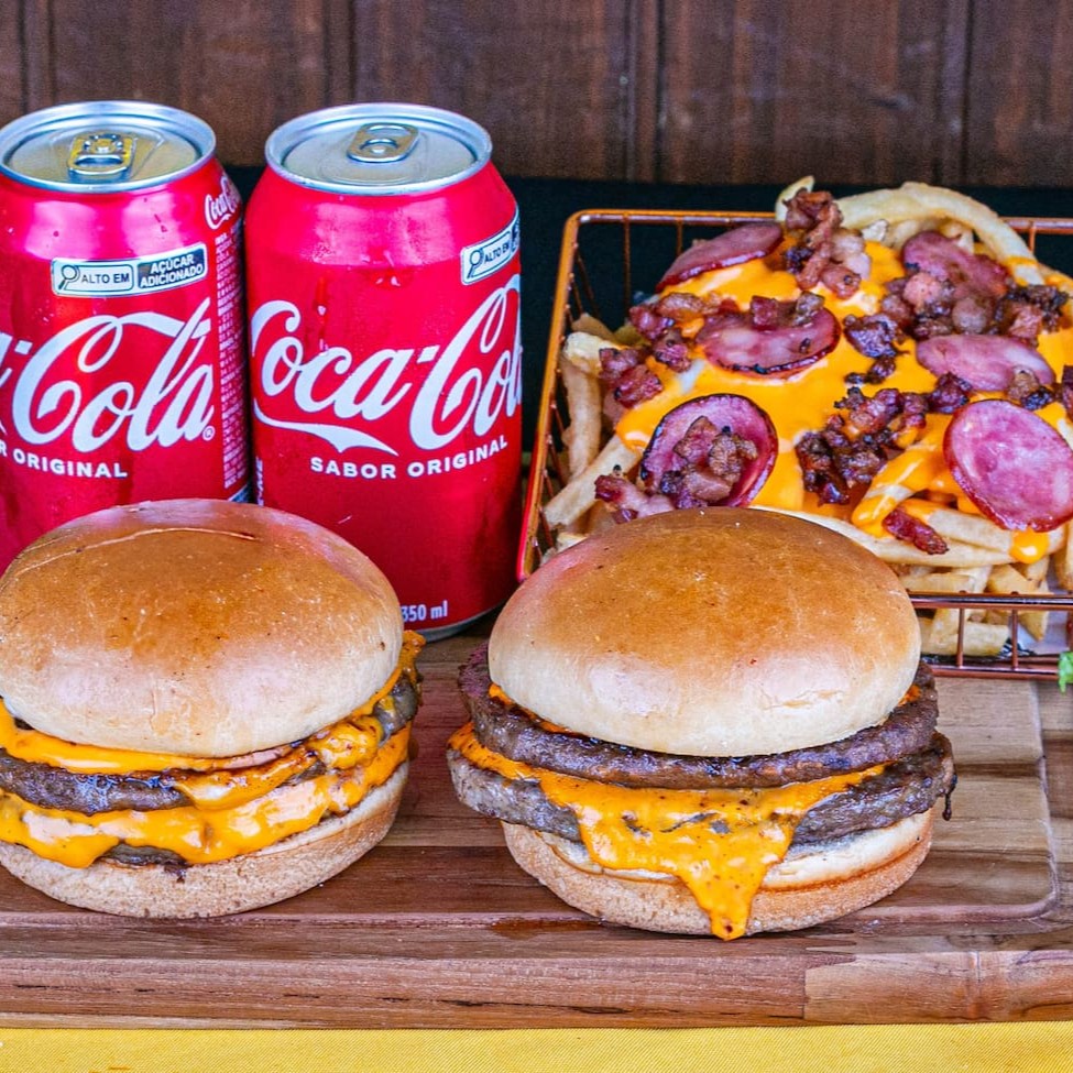Desfrute do nosso irresistível combo parceiro: 2 suculentos duplos cheddar, acompanhados de batata maluca crocante e 2 refrescantes latas de Refrigerante (*Especificar sabor de refrigerante) de 350 ml. Uma explosão de sabores que vai deixar seu Dia muito mais especial!