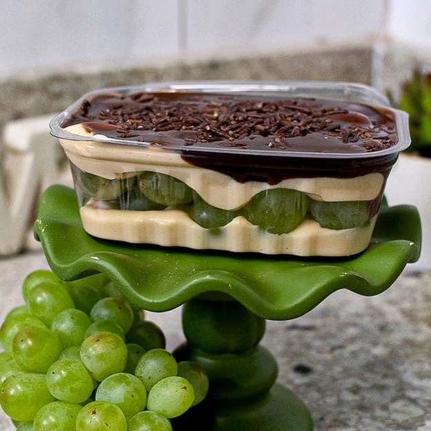 Bombom no pote irresistível, com duas camadas de recheio artesanal de chocolate branco com Ninho e pedaços frescos de uva, criando uma mistura perfeita de cremosidade e frescor. Finalizado com ganache de chocolate meio amargo e um toque macio de granulé, proporcionando um equilíbrio único entre o doce e o amargo. Uma explosão de sabores em cada colherada!