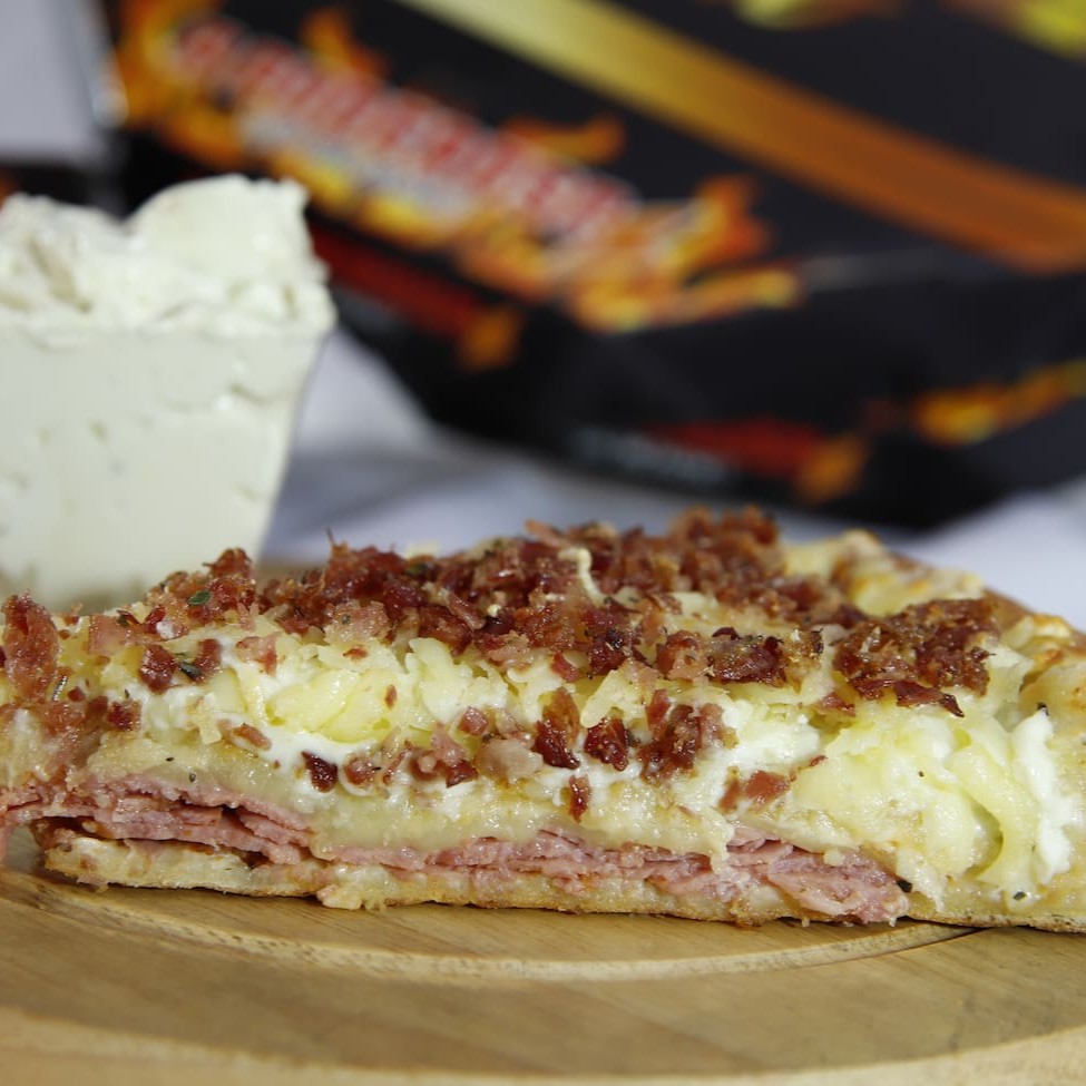 Uma deliciosa pizza de 2 andares, que serve de 2 a 4 pessoas. 1º And. Molho; Calabresa(Aurora); Muçarela 2º And.: molho especial; provolone; parmesão; Bacon e Orégano Borda: Muçarela; Requeijão e Cheddar.